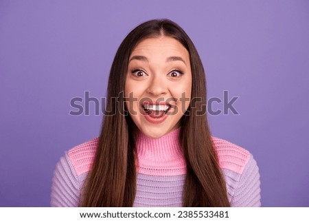 Surprised young pretty girl looking at the camera isolated on violet background.