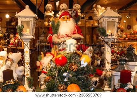 Christmas market stall with Santa Claus figurine and christmas tree gifts for sale Royalty-Free Stock Photo #2385533709
