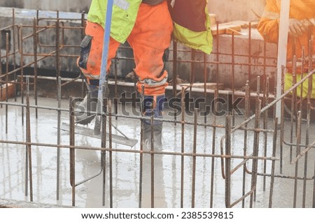 Concrete cast-in-place work. Builder level wet concrete. Concrete works on buildiiing construction site Royalty-Free Stock Photo #2385539815