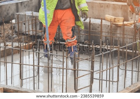 Concrete cast-in-place work. Builder level wet concrete. Concrete works on buildiiing construction site Royalty-Free Stock Photo #2385539859