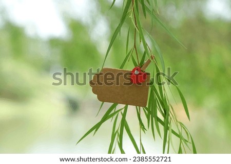 Blank hanging note on the tree with red love clip