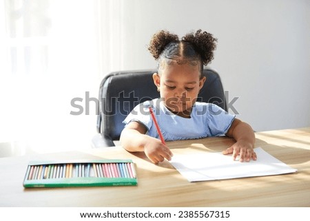 African child girl drawing with color pencil on paper