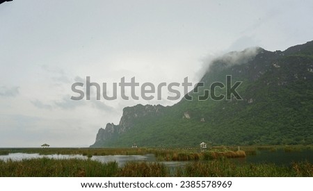 Wooden walkway and pavilion in the middle of freshwater marsh, blue sky, cloudy and prohibition Signs. Sam Roi Yot Freshwater Marsh or Bueng Bua Khao Sam Roi Yot National Park in Thailand. Royalty-Free Stock Photo #2385578969