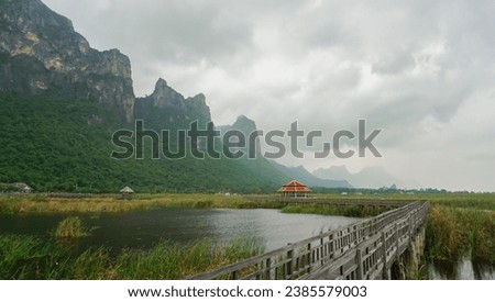 Wooden walkway and pavilion in the middle of freshwater marsh, blue sky, cloudy and prohibition Signs. Sam Roi Yot Freshwater Marsh or Bueng Bua Khao Sam Roi Yot National Park in Thailand. Royalty-Free Stock Photo #2385579003