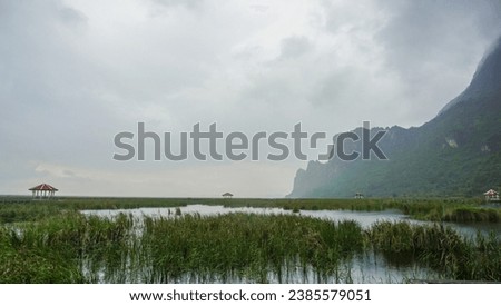 Wooden walkway and pavilion in the middle of freshwater marsh, blue sky, cloudy and prohibition Signs. Sam Roi Yot Freshwater Marsh or Bueng Bua Khao Sam Roi Yot National Park in Thailand. Royalty-Free Stock Photo #2385579051