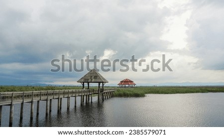 Wooden walkway and pavilion in the middle of freshwater marsh, blue sky, cloudy and prohibition Signs. Sam Roi Yot Freshwater Marsh or Bueng Bua Khao Sam Roi Yot National Park in Thailand. Royalty-Free Stock Photo #2385579071