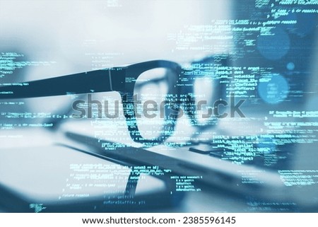 Close up of laptop on desk with glasses, smartphone and creative coding html language on blurry background. Web developer and programming concept. Double exposure