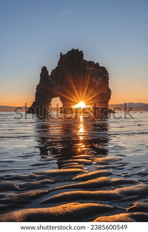 Sunrise Gleaming through an Artistic Volcanic Rock Sea Stack Monolith in North-West Hvítserkur, Iceland Royalty-Free Stock Photo #2385600549