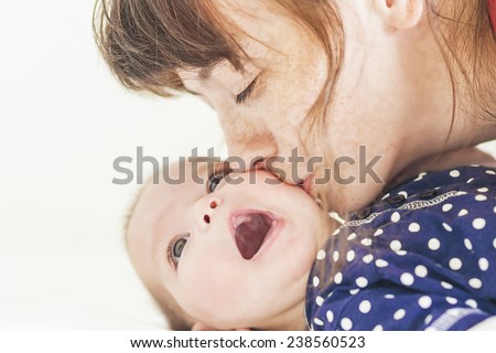Happy Caucasian Mother Kissing Her Newborn Little Child. Horizontal Image Composition