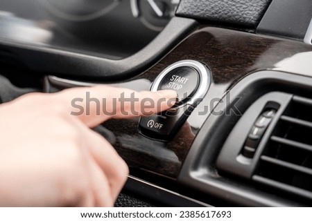 Pushing a start ignition button switch in the car. Driving Royalty-Free Stock Photo #2385617693