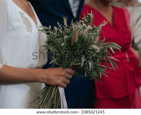 Bride holding her bucket of flowers before entering to the church. Close up picture. Celebration, commitment, excitement concept. 