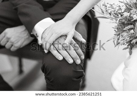 Just married. Close up picture of two hands holding wearing rings. Husband and wife. Black and white picture.