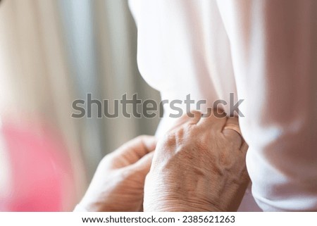 Hands of a woman fixing the bride's wedding dress. Close up picture
