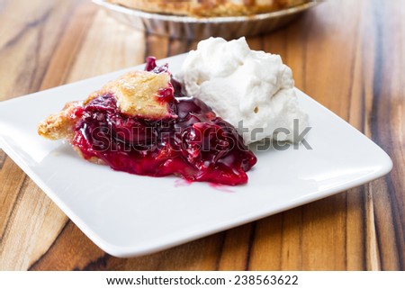 view form above of a fresh baked cherry pie with a slice on a white plate