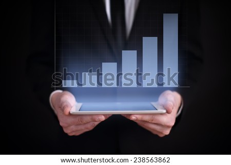Businessman holding a tablet with the projection graph on screen. business concept. financial growth. stock market trading. Exchange Rates. success