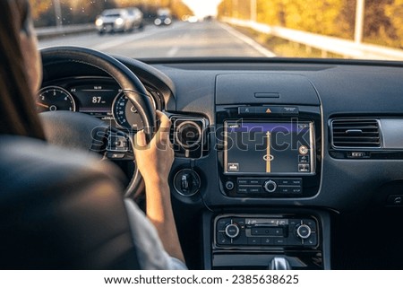 Woman driver hands on steering wheel inside car. Royalty-Free Stock Photo #2385638625