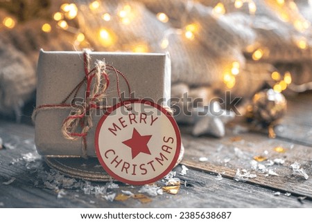 Cozy composition with a Christmas gift box on a blurred background. Royalty-Free Stock Photo #2385638687