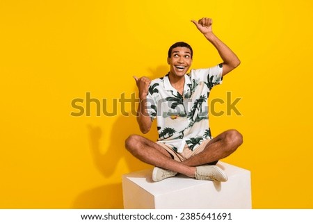 Full length photo of nice young male cube point look empty space dressed stylish palms print garment isolated on yellow color background