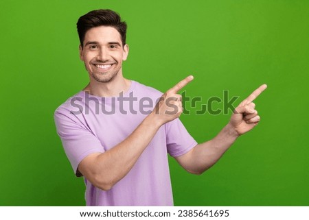 Photo portrait of handsome young man point cheerful empty space dressed stylish purple outfit isolated on green color background