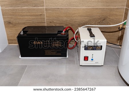 Emergency power supply with a 12V 65Ah battery providing uninterrupted pure sinusoidal alternating voltage of 230 Volt. Royalty-Free Stock Photo #2385647267