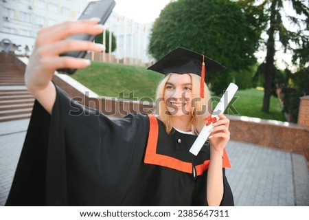 Young female student graduating from university take selfie.