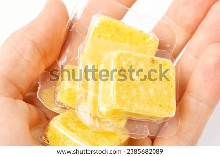 Soup cubes in hand. Yellow soup cubes. High quality photo
