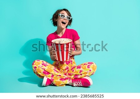 Full length photo of excited cute woman dressed flower print trousers enjoying films pop corn empty space isolated teal color background