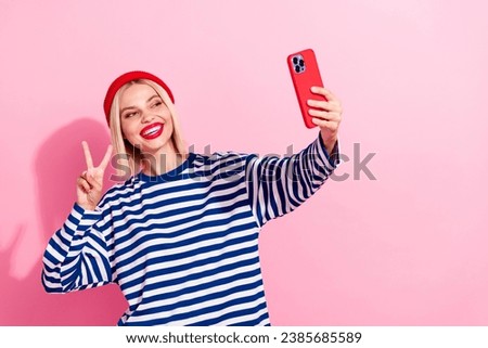 Photo of charming shiny girl dressed striped shirt showing v-sign tacking selfie empty space isolated pink color background