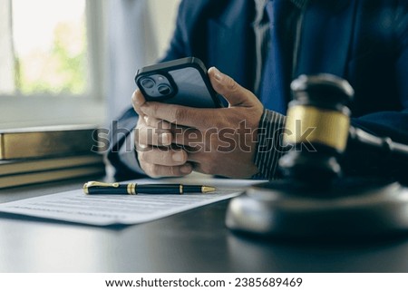 Male lawyer working at table in office focusing on scales of justice, lawyer holding pen and giving legal advice, business dispute service with hammer Close-up pictures