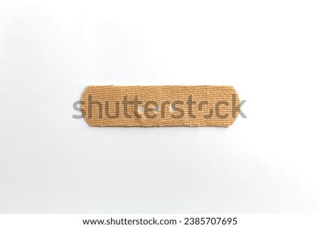 Medical aid band on white background. Punctuation mark made with a band aid dash, hyphen.