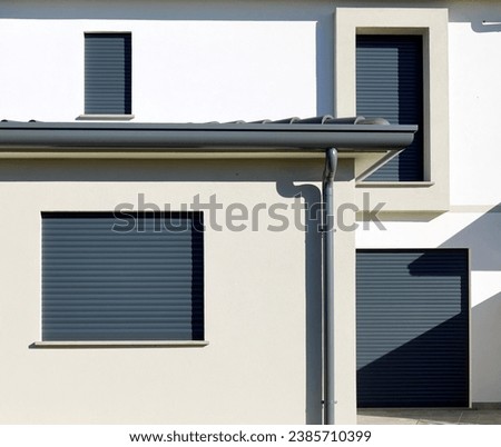 Dark gray security rolling shutters on a facade of a new built house. Royalty-Free Stock Photo #2385710399
