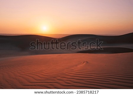 Sand dunes against sky at sunrise. Desert Wahiba Sands in Sultanate of Oman.
