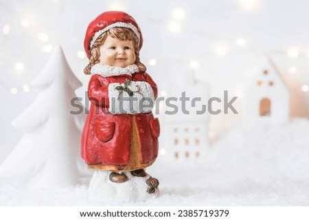 Retro Christmas card with a cute figure of a child on a snowy background. A girl in a red coat warms her hands in a muff. The concept of the winter holiday new year 2024.