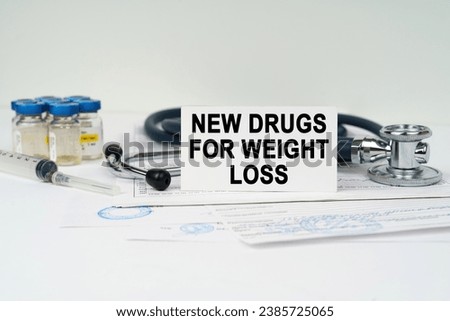 Medical concept. On the medical documents there is a stethoscope, injections, a syringe and a business card with the inscription - new drugs for weight loss Royalty-Free Stock Photo #2385725065