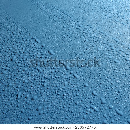 blue background sprinkled with drops of bright water of different sizes