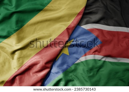 big waving national colorful flag of republic of the congo and national flag of south sudan . macro