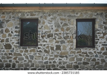 wooden frame window on stone wall. Full frame of a ancient facade of a stone wall with a window of wood illuminated by the light of the sun. High resolution photography. Gonio fortress. Batumi Georgia