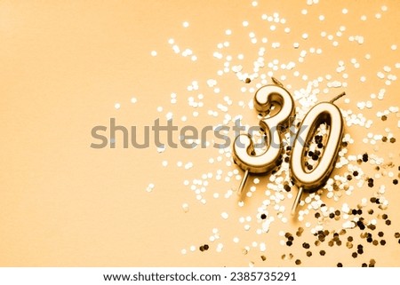 30 years celebration festive background made with golden candles in the form of number Thirty lying on sparkles. Universal holiday banner with copy space.