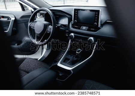 Modern black car interior, leather steering wheel, climate control, navigation, air ducts, deflectors on the car panel. Details interior.  Royalty-Free Stock Photo #2385748571
