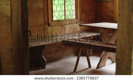 Swiss Chalet interior, close-up of wooden furniture, chair and table. Simple cozy living inside traditional handmade farmhouse Royalty-Free Stock Photo #2385770837