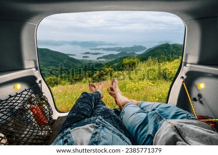Low section of people in car looking at beautiful mountain landscape Royalty-Free Stock Photo #2385771379
