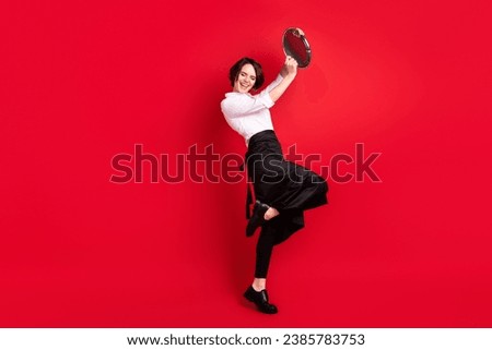 Full body photo of charming funky young woman raise tray enjoy work wear apron isolated on red color background