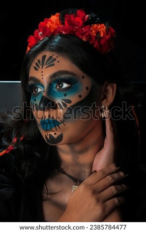 A young Mexican girl dressed as Catrina for the celebration of the Day of the Dead, posing for a photo session prior to the parade, part of the culture and tradition of Mexico. MyRealHoliday