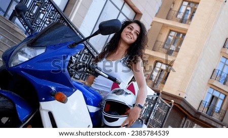 Independent and beautiful girl posing on her motorcycle