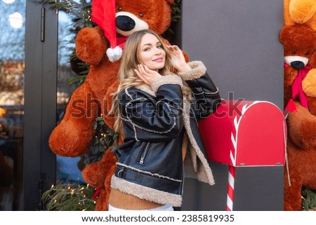 a young girl on the eve of the New Year and Christmas holidays near a cafe window decorated with New Year's teddy bears