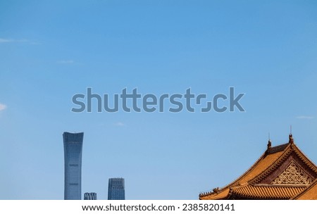 Chinese traditional building and tall modern buildings against blue sky. Beijing, China