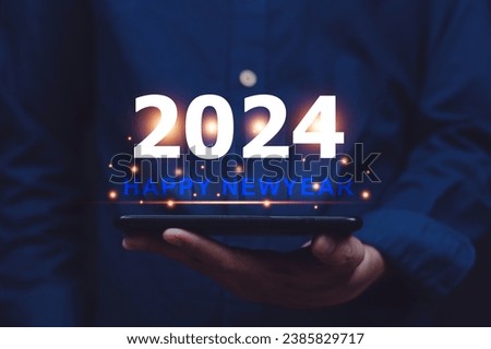 Hand holding mobile phone send message happy New year 2024