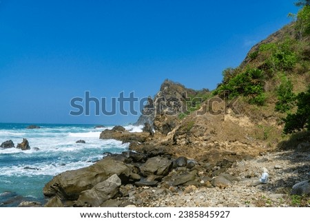 Rocky shoreline of Watu Lumbung Beach, Indonesia. Tidal waves hits the coral rock
