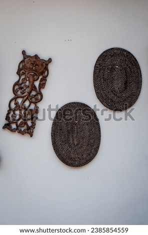 Traditional wall decoration made from wood and rattan hanging on a white whall of a villa in Bali, Indonesia
