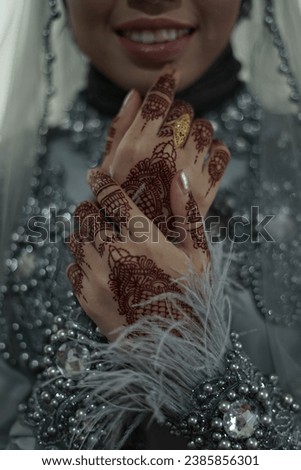 wedding picture of a bride showing off her henna arts on her hands.